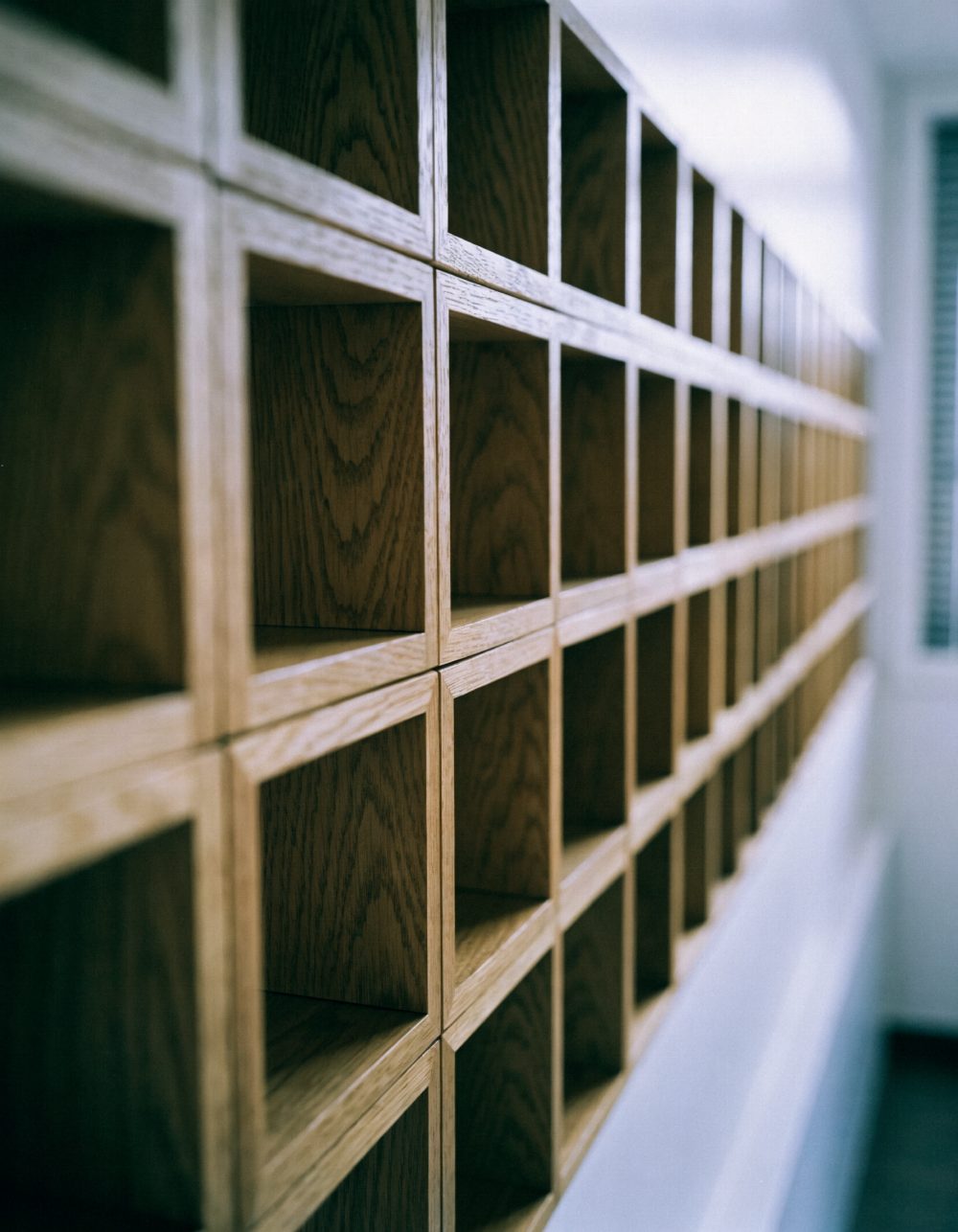 Wand mit getrennten Holzfächern Wand aus einzelnen, voneinander getrennten Holzfächern in einem hellen Büro – KI-generiertes Symbolbild